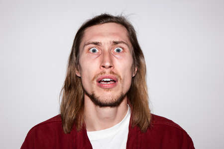 Surprised young male. Shocking news. Astonished man emotion, handsome guy portrait, facial expression conceptの写真素材