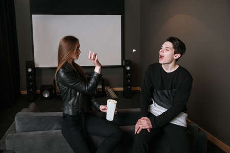 Young people friendship. Fun background. Couple in home cinema, creative pastime togetherの写真素材