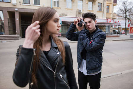 Street photo shoot process. Creative lifestyle. Modern young people in selective focus, beautiful female model, stylish youth outdoorsの写真素材