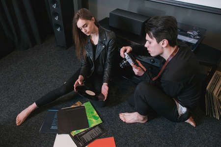 Hipsters take picture of their hobby. Love for retro vinyl records. Modern youth lifestyle, creative pastime togetherの写真素材