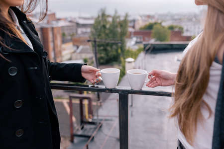 Friends at tea party in fresh air. Rest at nature, creative breakfast. Drink commercial background, unrecognizable girls on streetの写真素材