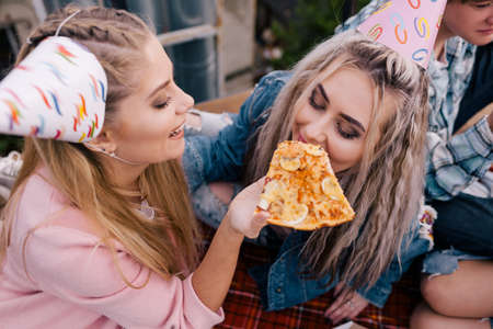 Students birthday party celebration. Leisure time. Girls and fast food, happy emotionsの写真素材