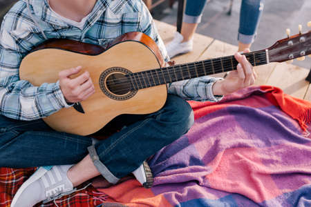 Guitarist at student party celebration. Unrecognizable male with guitar outdoorsの写真素材