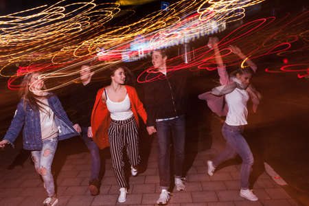 Young people party in city. Free nightlife. Happy students outdoors, strong friendship, bright lights backgroundの写真素材