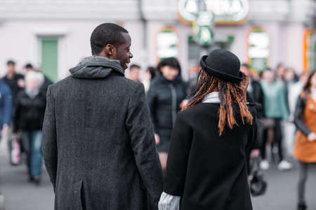Stylish pedestrians on crowd background. African American couple. Unrecognizable young people on...