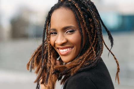 Happy young black woman smile. Joyful mood. Stylish smiling model, African American female in selective focus outdoors, happiness conceptの写真素材