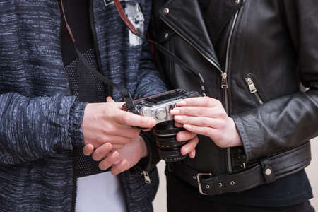 Relationship and technology. Romantic concept. Street photo shoot, unrecognizable stylish people, gentle touchesの写真素材