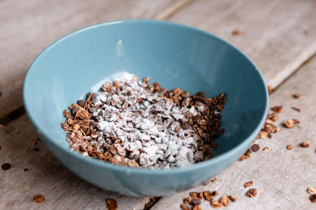 Healthy cereal breakfast on wooden background. Sweet granola in teal bowl. Wholegrain vegetarian morning tasty food.の写真素材