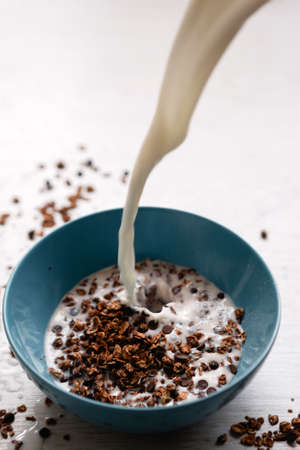 Healthy cereal breakfast cooking. Sweet granola with milk on white background. Wholegrain vegetarian morning tasty food.の写真素材