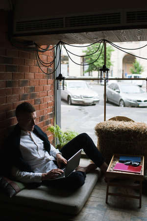 Remote work in comfort place. Communication in social media, freelancer in cafe. Self-education for young man, technology conceptの写真素材