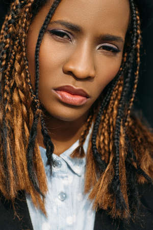 Young female fashion portrait. Pretty black woman. Creative haircut in selective focus, facial expression, beauty conceptの写真素材