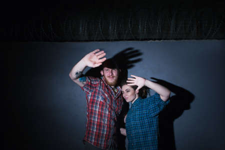 Caught criminals. Dark crime scene. Forbidden love relationships, young couple on blue background,...