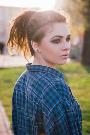 Stylish hipster girl. Thoughtful lady. Female fashion portrait in focus on foreground, urban life, atmospheric backlight, beauty conceptの写真素材