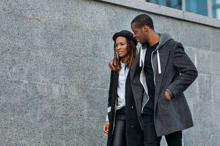 Active black couple outdoors. Happy relationships. Fun leisure time, stylish African American pedestrians on date, love conceptの写真素材