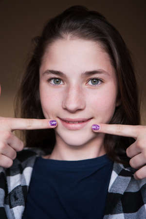 Positive teenage life. Jolly childhood. Smiling beautiful girl with long hair and clean skin in focus on foreground. Joyful child portrait closeup, beauty conceptの写真素材