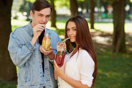 Healthy nutrition. Couple drinking fresh juice detox tea. Young friends lifestyle, vegetarian diet, fitness food on the go, weight loss together conceptの写真素材