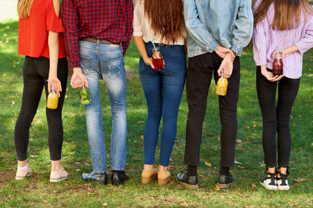 Time to detox. Youth with fruit juice cocktails on green summer nature background. Vegetarian lifestyle, fitness food on the go conceptの写真素材