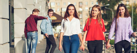 Group of young man flirting with women in city. Friendship, leisure, students lifestyle, first love, communication conceptの写真素材