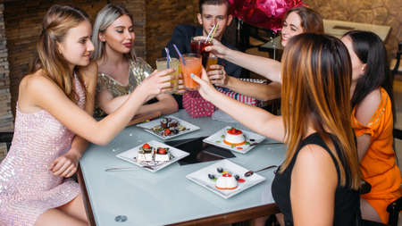 Birthday party celebration. Happy toast. Youth company in cafe with drinks. Modern leisure time, good friends together, festivity conceptの写真素材