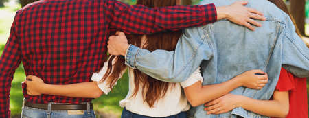 Best friends forever. Group of happy young unrecognizable man and woman hugging together and talking on city street from back. Happiness, leisure, friendship, teamwork, family travels conceptの写真素材