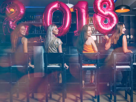 New Year females party at bar. Unrecognizable women group, friends celebration. Club background, festive moodの写真素材