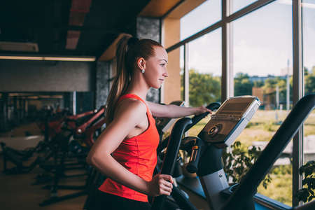 Sport girl run orbitrek gym body fitness concept. Hard cardio workout. All for the    of achieving...