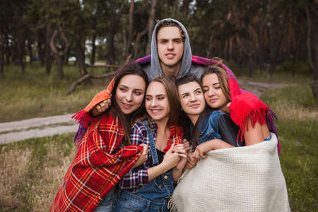 Friends group warm together blanket hiking concept. Tourist lifestyle. Happy team on the nature.の写真素材