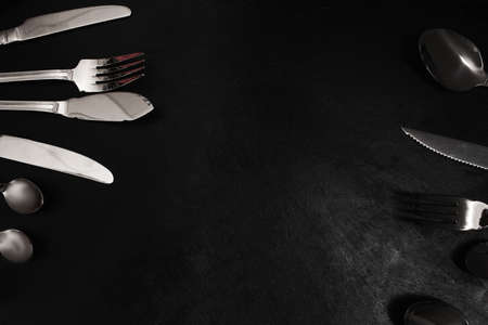 Silver cutlery on black background. Table setting for banquet conceptの写真素材
