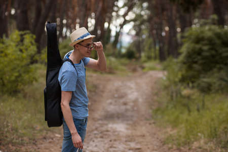 Smiling guitar man life nature stroller concept. Active lifestyle. Unity with the nature.の写真素材