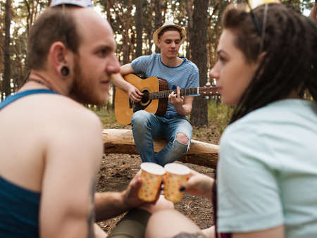 Friends guitar music couple picnic party nature concept. Traveler lifestyle. Hiking happy moments.