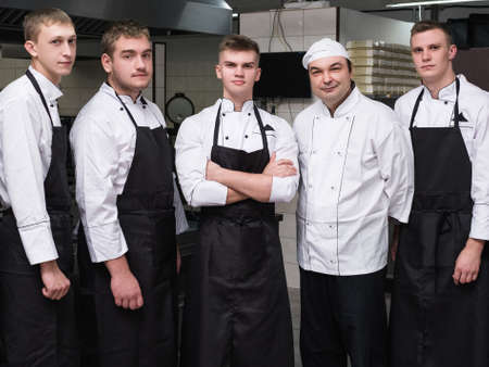 Chef and his team of professional staff at restaurant. Teamwork brings success to any businessの写真素材