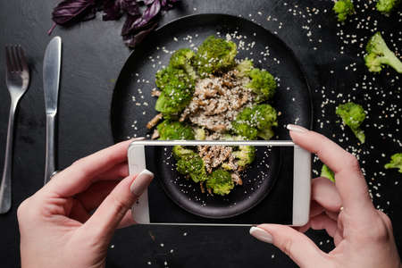 food blogger make mobile photo of vegetable salad. social network activity. proper nutrition lifestyle.の写真素材
