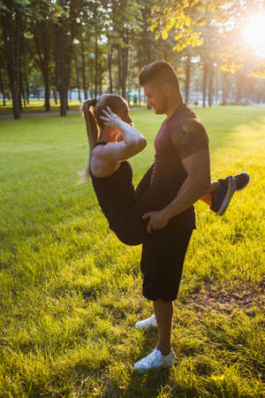 love sportsman couple support workout outdoor concept. exercises for the abs. romance of active people.の写真素材