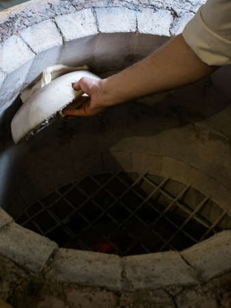 Chef making khachapuri in tandoor. Traditional Georgian starchy food mealの写真素材