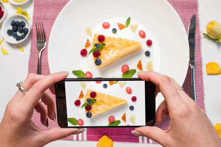 food blogger dessert smartphone lifestyle concept. creative vision. delicious cheesecake.の写真素材