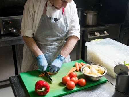 Meal preparation process. Chef cutting carrot. Healthy vegetable dish recipeの写真素材