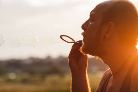 Man bubble blowing portrait nature concept. Unity with the nature. Traveler leisure.の写真素材