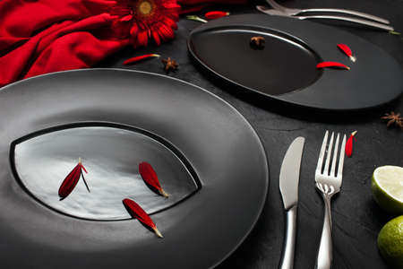 Matte plate on black background with red accent color. Restaurant table layout for fancy dinner...