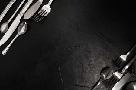 Silver cutlery on black background. food etiquette concept