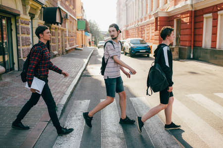 urban teenage hipster street lifestyle. students go to college or high school to study. crosswalk traffic laws conceptの写真素材