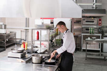 Restaurant kitchen interior. Workspace of talented and successful cooks. Clean and tidy working surfacesの写真素材