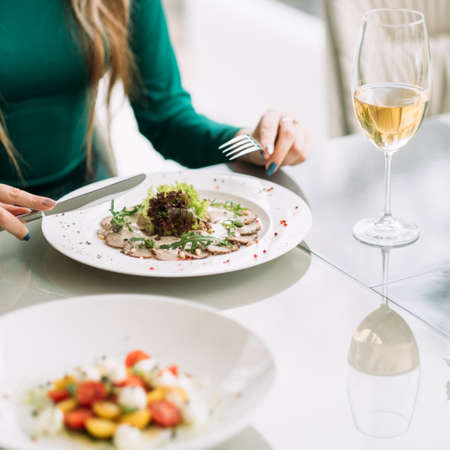 Woman having dinner at a restaurant. Healthy food lifestyle. Business lunch conceptの写真素材