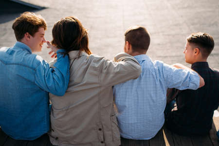Men friendship. Back view of young teenagers hugging. Bff support unity teamwork conceptの写真素材