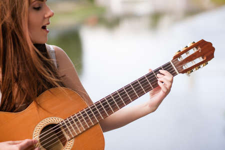 Guitar romantic city musician performance. woman playing stringed instrument and singing. Lifestyle...