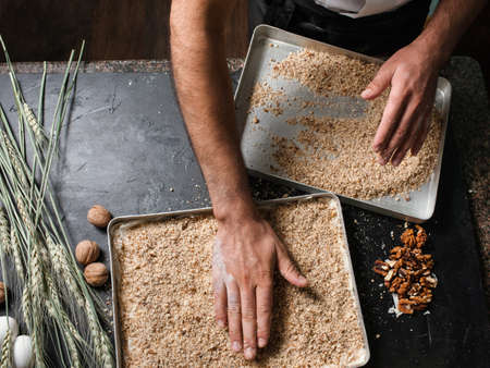 Food pastry dessert recipe concept. Chef making  baklava with nuts at restaurant.の写真素材