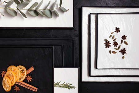 Strict black and white bakckground with spices, herbs and citrus. Aromatic ingredients for hot tasty...