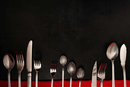 Silver cutlery on black background. food etiquette conceptの写真素材