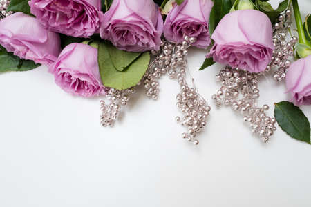 Spring wedding flowers decor. Pink roses with silver adornment on white background. Elegant and tender reception party flower arrangementの写真素材
