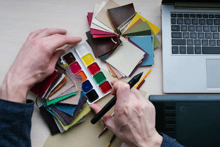 Color swatches palette. Must have tool for designers. Colour combination, art creation. Man choosing the suitable shade for his designの写真素材