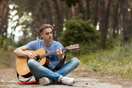 Music lifestyle man playing guitar concept. Stroller man at the nature.の写真素材